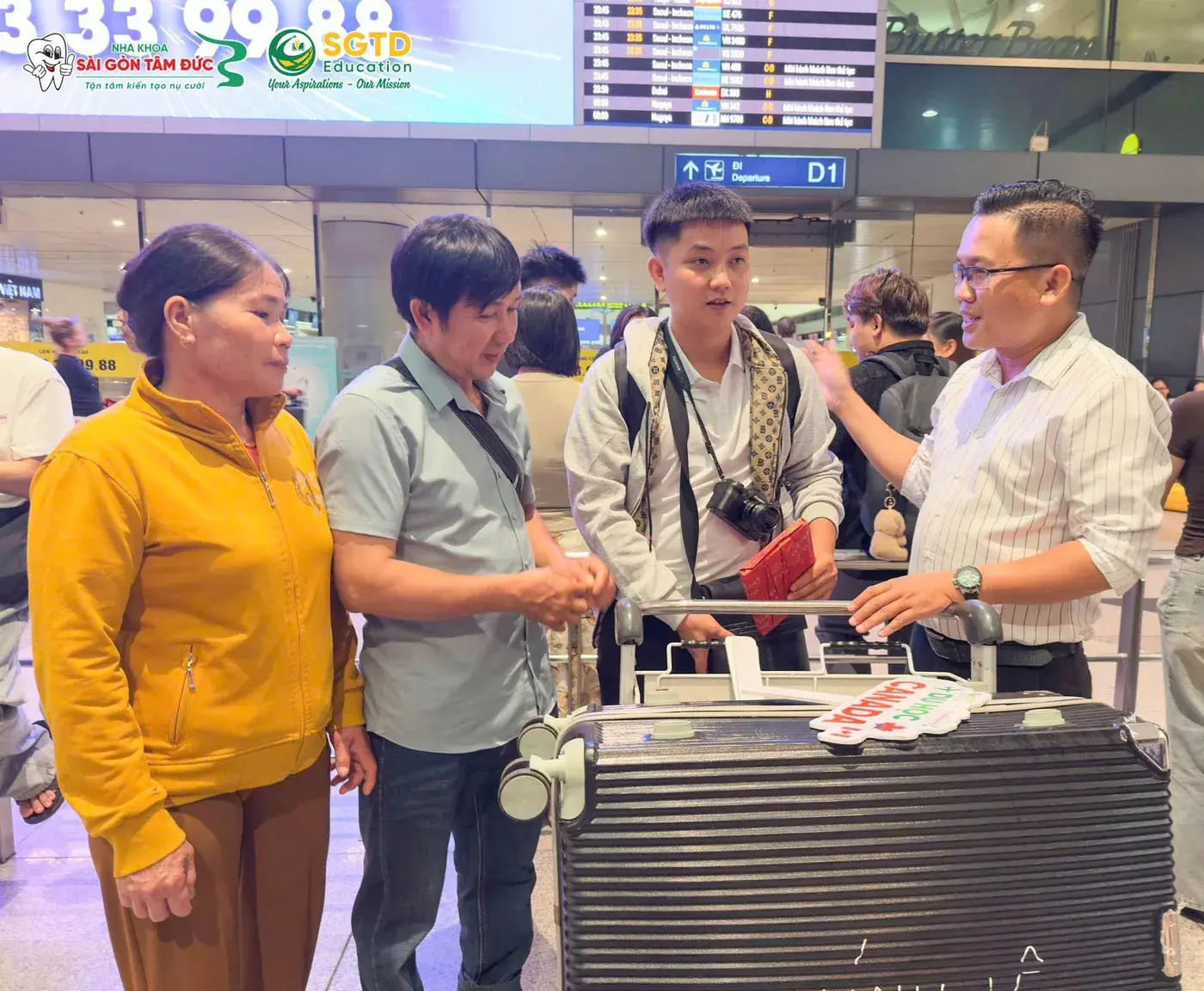 Đại diện SGTD Education trò chuyện cùng Giang Khánh và gia đình tại sảnh đi, trên tay Giang Khánh là món quà vừa nhận
