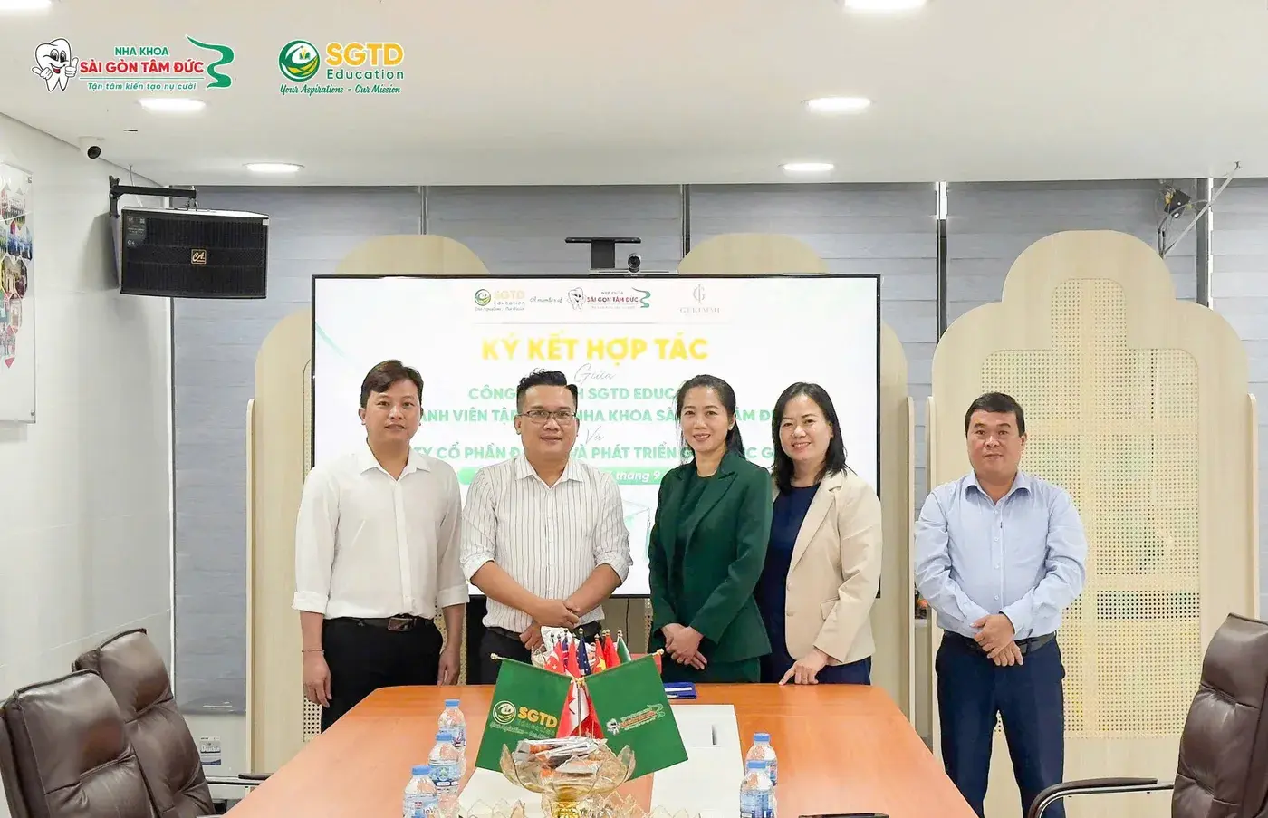 Ảnh lưu niệm của đại diện hai đơn vị trước màn hình lễ ký kết hợp tác