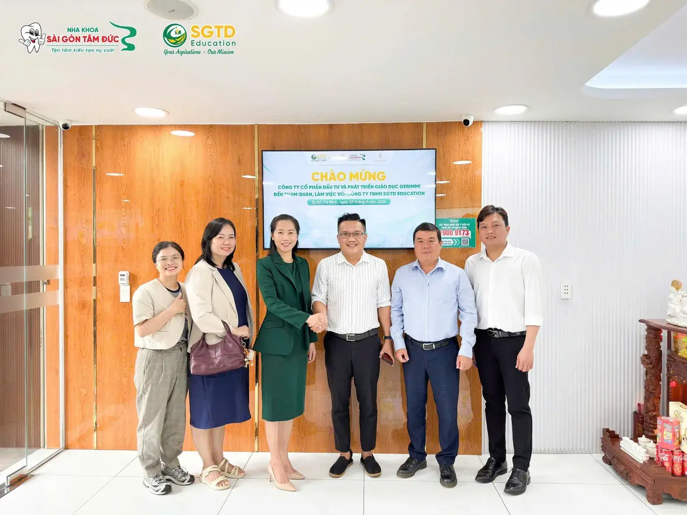 Đại diện SGTD Education và Gerimmi bắt tay trước màn hình chào mừng đoàn đến tham quan, làm việc