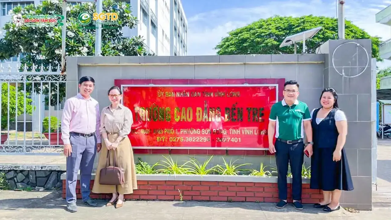 Đoàn công tác tại bảng tên Trường Cao đẳng Bến Tre, điểm dừng cuối của chuyến đi
