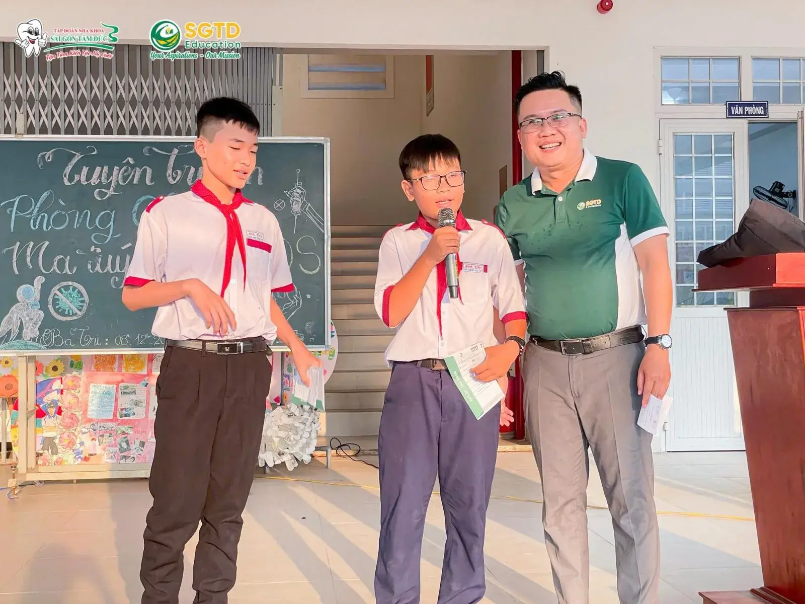 Học sinh ngồi nghe chia sẻ và nhận tài liệu