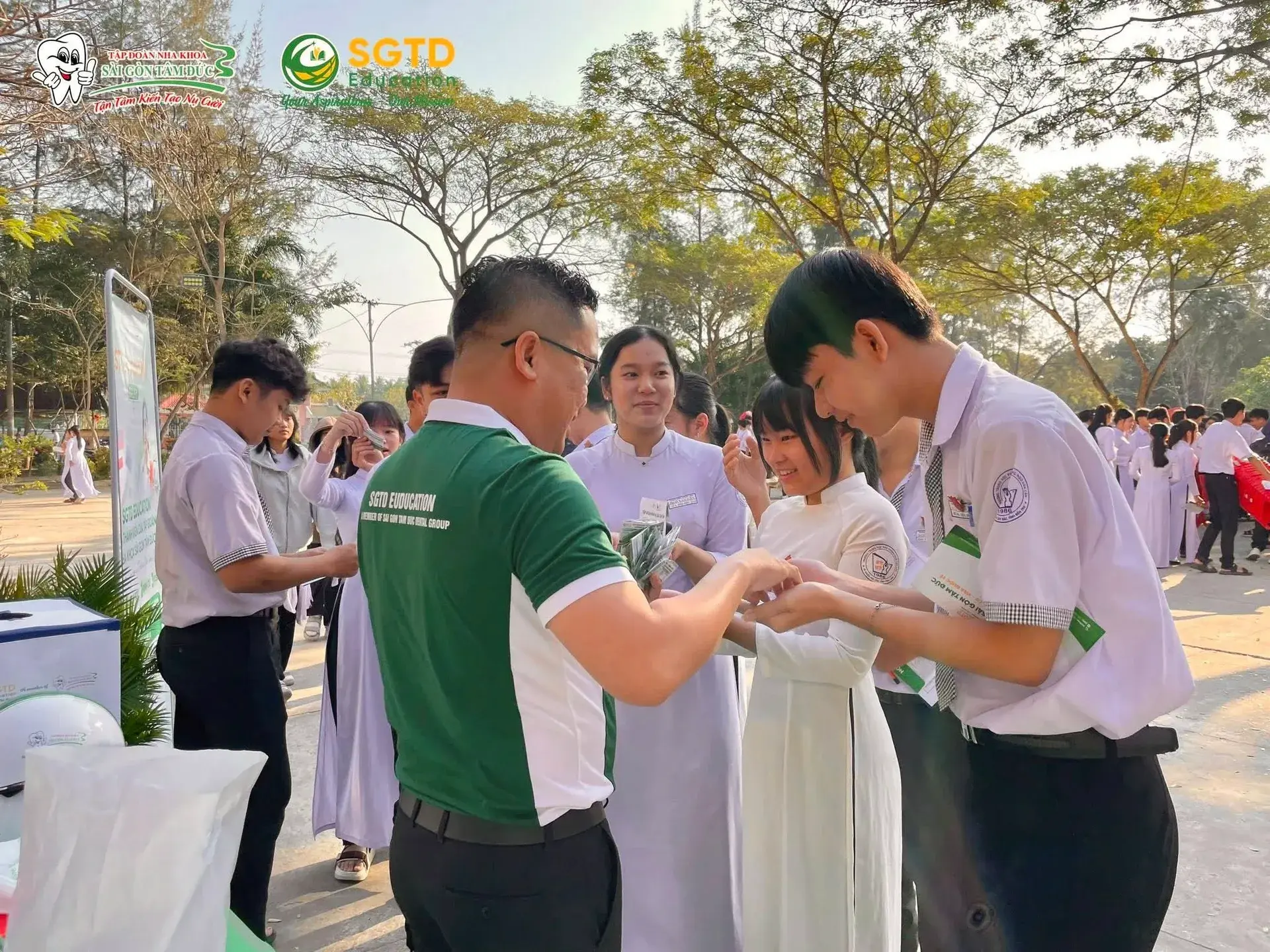 Nhóm học sinh chụp ảnh cùng các biển hiệu du học tại sân trường