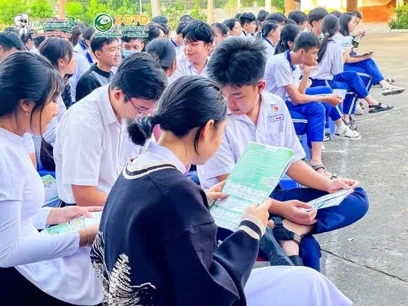 Học sinh đọc tài liệu du học trong buổi chào cờ