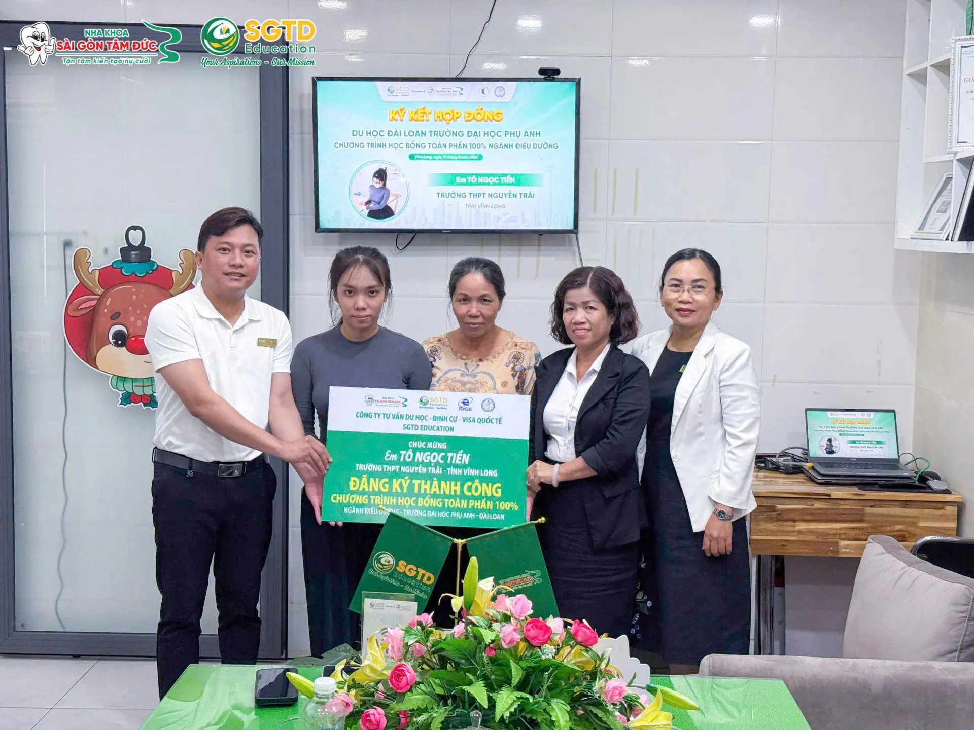 Tô Ngọc Tiền nhận bảng chúc mừng đăng ký thành công học bổng Điều dưỡng tại Đại học Phụ Anh, Đài Loan cùng đại diện SGTD Education